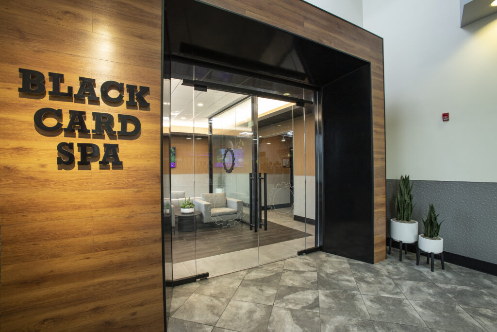 Planet Fitness "Black Card Spa" labeled on wood looking into sleek, natural waiting room